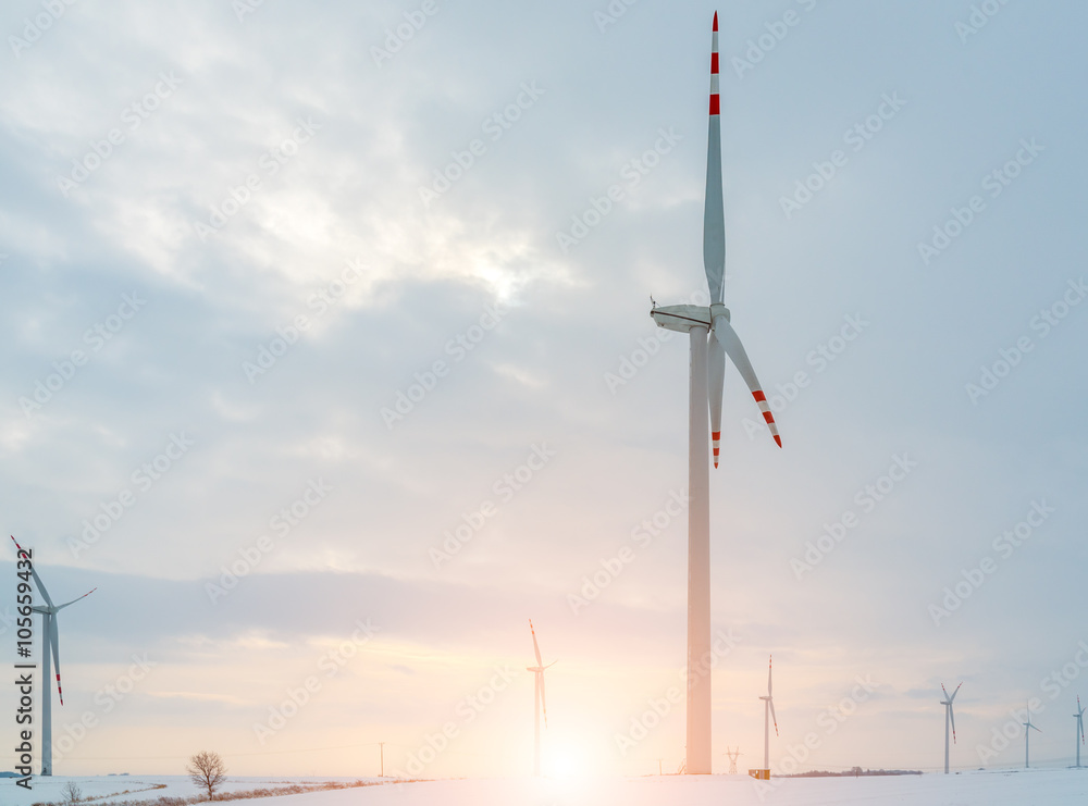 Sunset above windmill on the field in winter Sunset above windmill on the field in winter