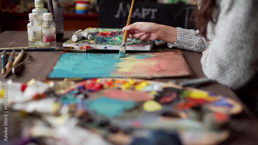artist paints a picture of oil paint brush in hand with palette closeup. artist paints a picture of oil paint brush in hand with palette closeup.