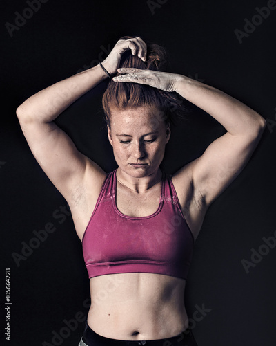 Female Athlete Tying Hair. Sportswoman Dark Gritty Strength & Determination photo