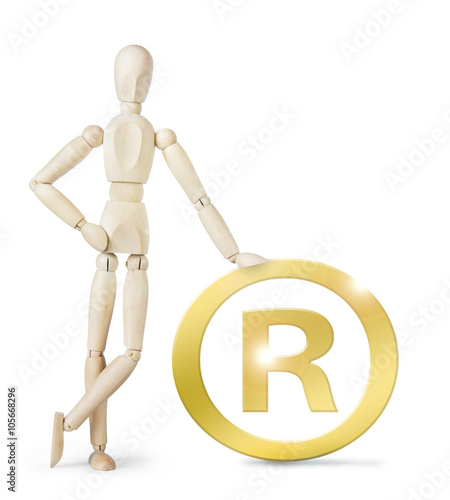 Man leaned against a large golden Registered sign. Abstract image with a wooden puppet