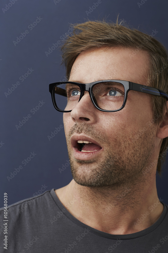 Obraz premium Surprised guy looking away in studio