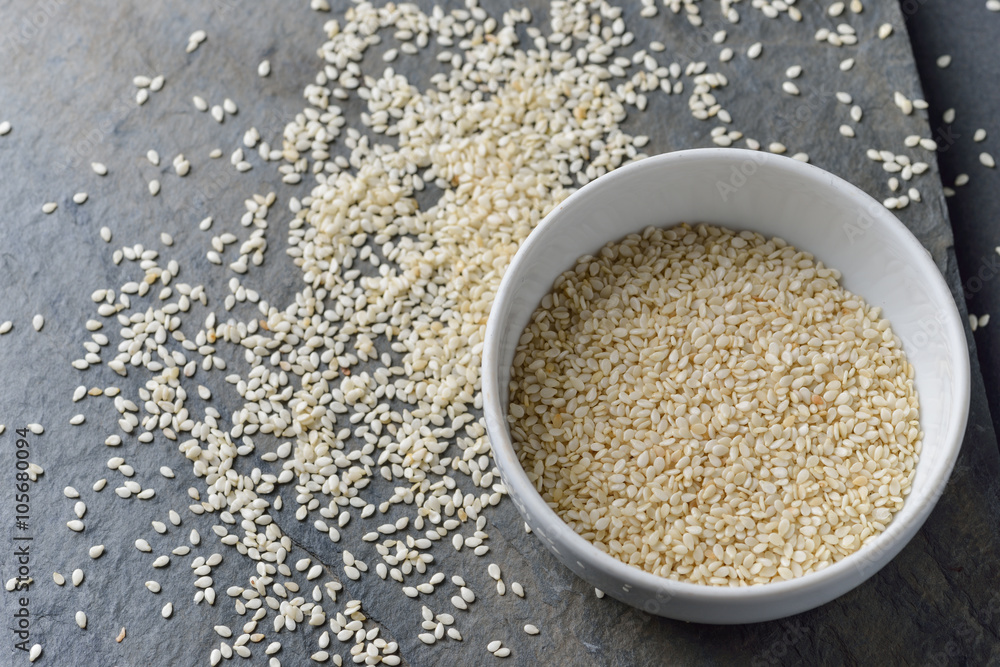 sesame seeds in bowl on rock background sesame seeds in bowl on rock background