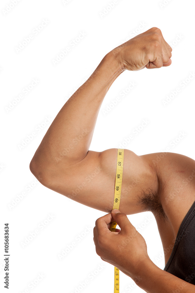 Muscular Asian man's arm flexing biceps with measuring tape Stock Photo