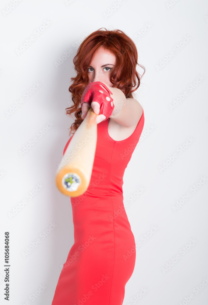 Elegant young redhead woman in little red dress and red leather gloves, brandishing a baseball bat Elegant young redhead woman in little red dress and red leather gloves, brandishing a baseball bat