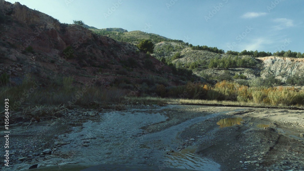 Offroad through a riverbed with a Jeep Wrangler, Andalusia, Spain Offroad through a riverbed with a Jeep Wrangler, Andalusia, Spain