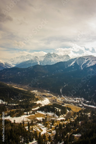 Aerial view of winter forest and snow-capped mountains