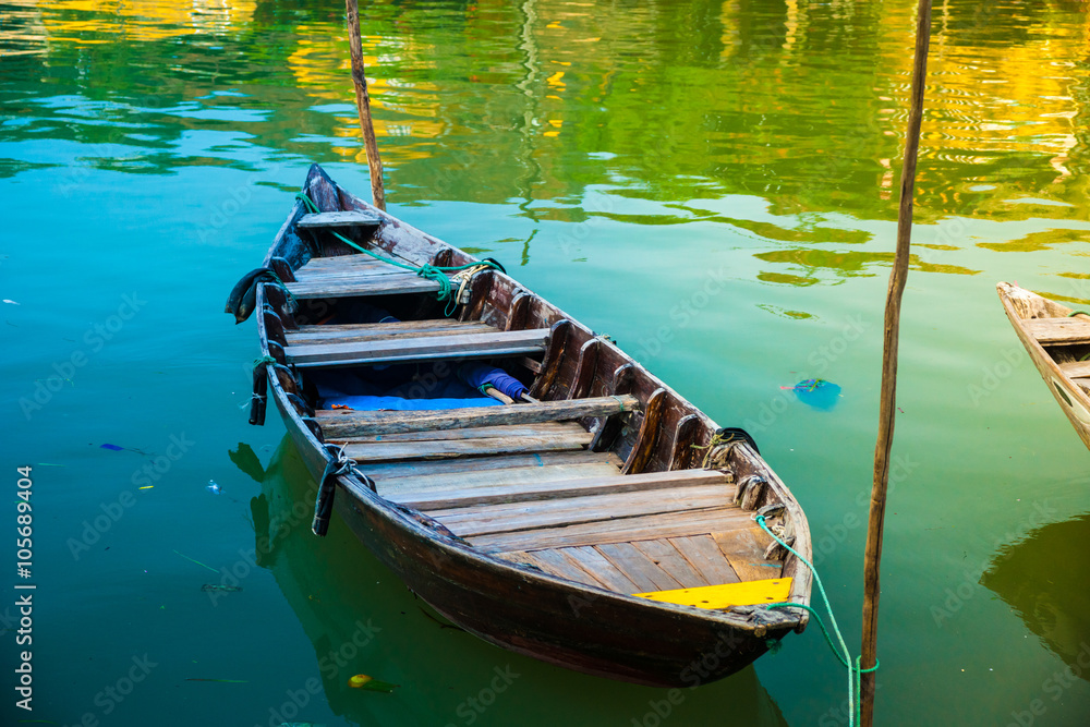 Fototapeta premium Traditional boats in front of ancient architecture in Hoi An, Vietnam. Hoi An is the World's Cultural heritage site, famous for mixed cultures & architecture.