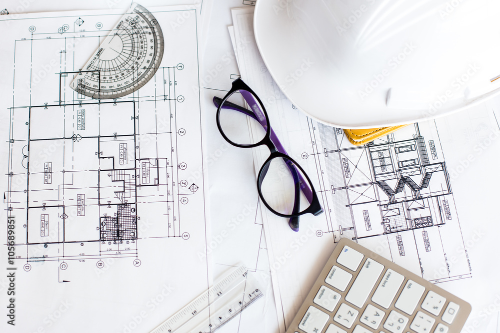 Image of blueprints with level pencil and hard hat on table Image of blueprints with level pencil and hard hat on table