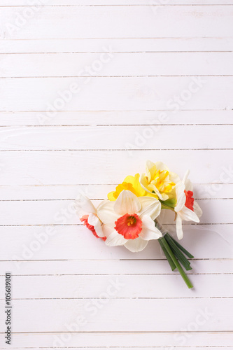 Cuadro en lienzo Yellow and pink narcissus flowers  on white  painted wooden plan