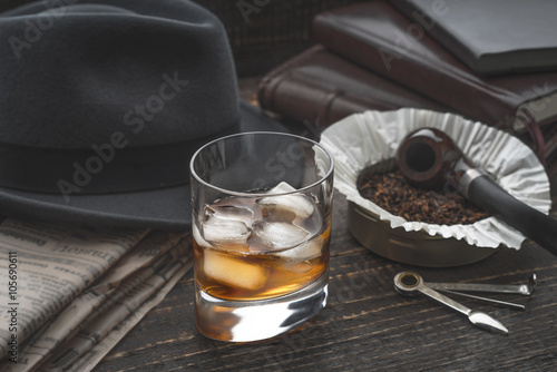 Whiskey with ice , pipe hat and newspaper photo