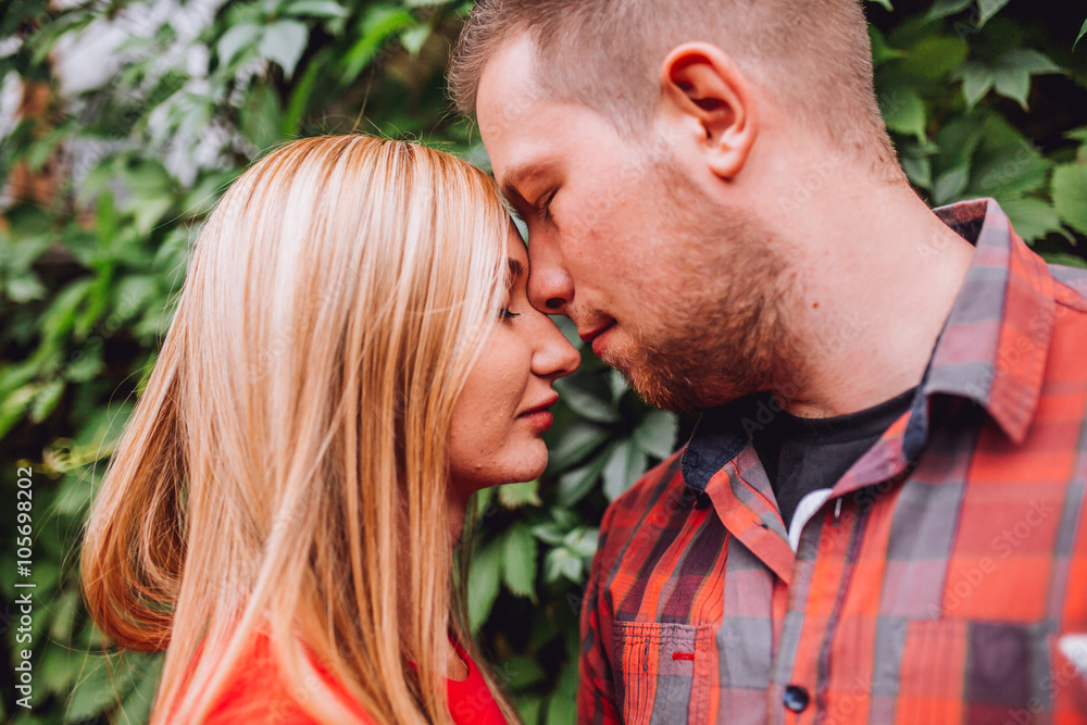 Young man and woman on the nature. Playful couple in love. Woman if red dress. Man in red shirt Young man and woman on the nature. Playful couple in love. Woman if red dress. Man in red shirt