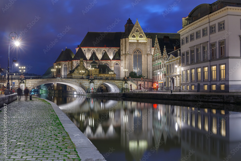 Quay Graslei, picturesque medieval St Michael's Bridge and church at night in Ghent, Belgium