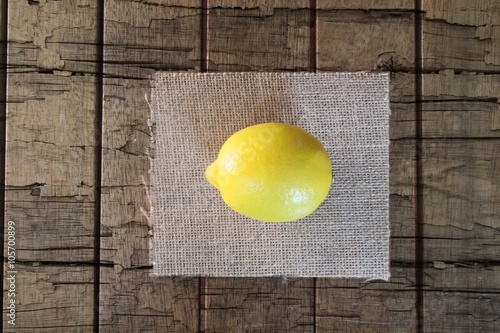 Simple yellow lemon on a rough wooden background