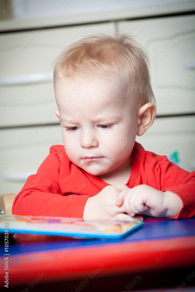 Small toddler or a baby child playing with puzzle shapes on a lo Small toddler or a baby child playing with puzzle shapes on a lo