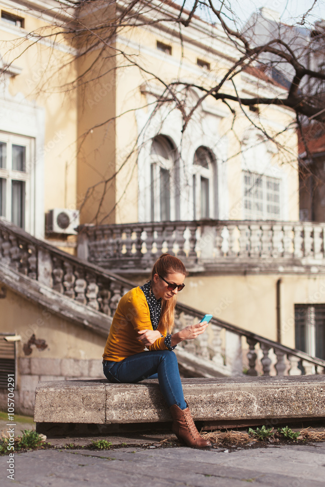 Young woman texting outdoors
