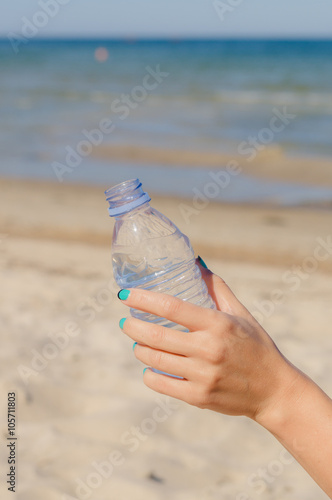 Female hand holding opened bottle of water