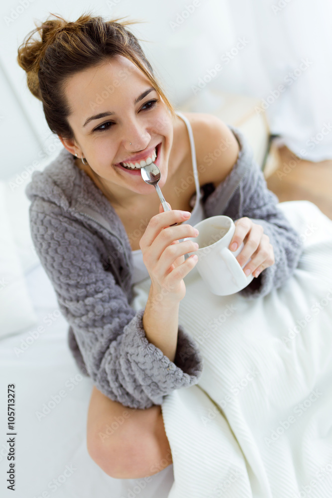 Beautiful young woman drinking coffee on bed. Beautiful young woman drinking coffee on bed.