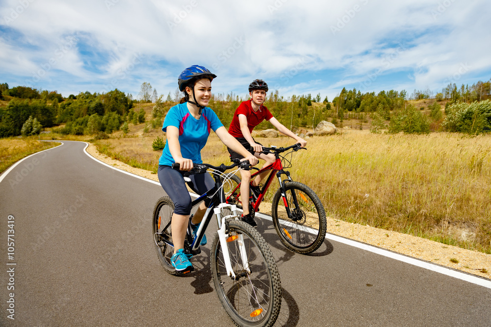 Fototapeta Healthy lifestyle - teenage girl and boy cycling