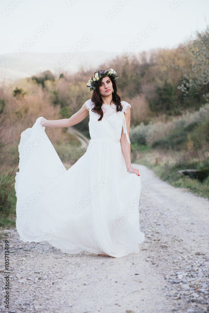 portrait of bohemian bride in nature, with white dress and crown