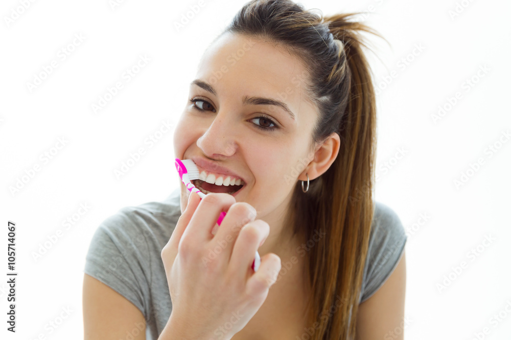 Pretty young woman brushing her teeth. Isolated on white. Pretty young woman brushing her teeth. Isolated on white.