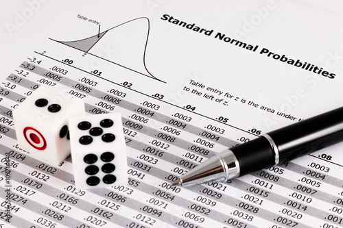 Two dice and pen on standard normal probabilities table.