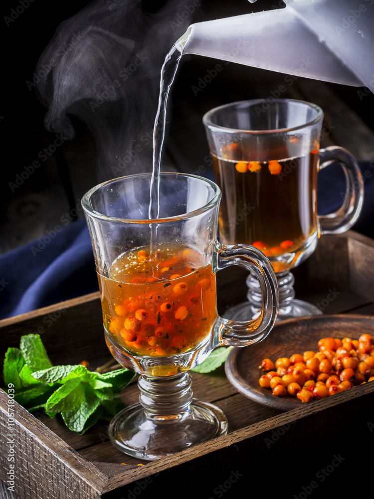 Hot tea flowing in glass cup with berries. Hot tea flowing in glass cup with berries.