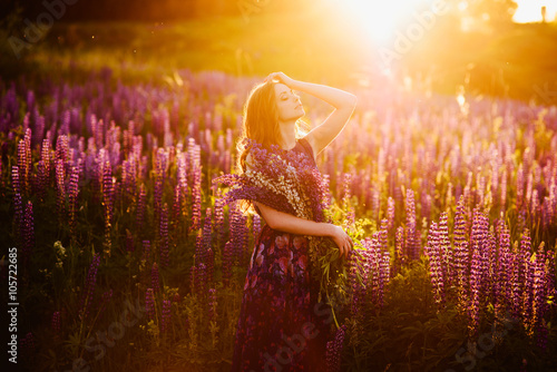 girl in field of purple wildflowers, sunset on Sunny day
