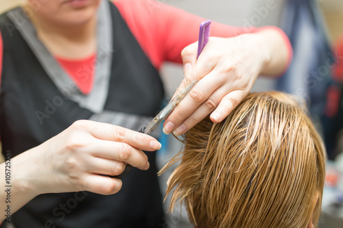 Female hair cutting scissors in beauty salon