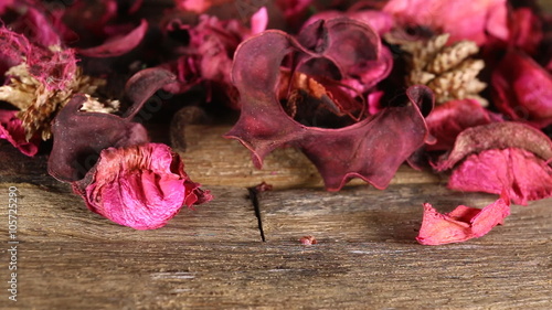 Red scented potpourri on dark wooden table. Macro shot.