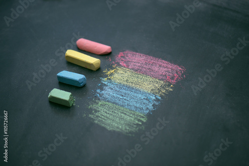 На школьной доске лежит мел разных цветов 