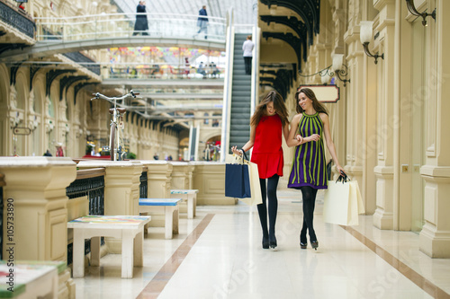 Two girlfriends on shopping walk on shopping mall with bags © Andrey_Arkusha