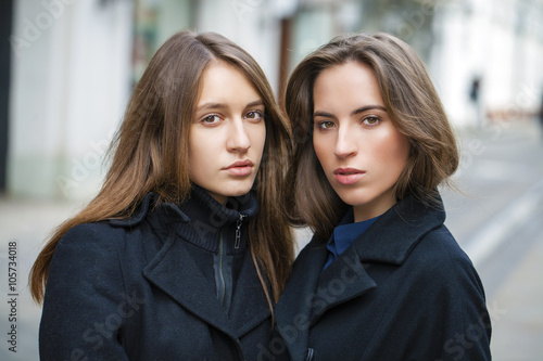 Close Up portrait of two friends in a black coat