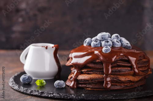 Chocolate pancake with chocolate frosting,blueberries and mint.selective focus
