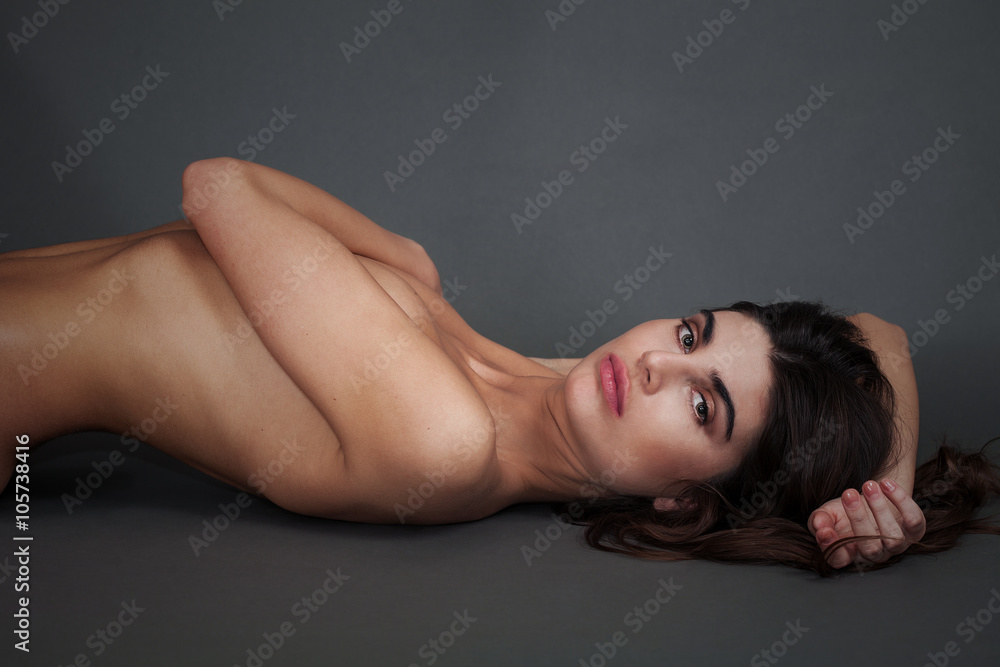 Naked woman portrait lying and looking at camera Naked woman portrait lying and looking at camera
