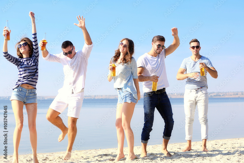 Obraz premium Young people with beer on the riverside
