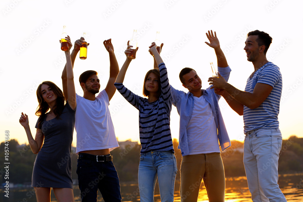 Young people with beer on the riverside Young people with beer on the riverside