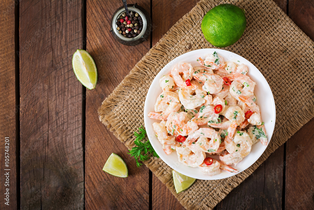 Shrimp in a creamy garlic sauce with parsley and lime in white bowl. Top view Shrimp in a creamy garlic sauce with parsley and lime in white bowl. Top view