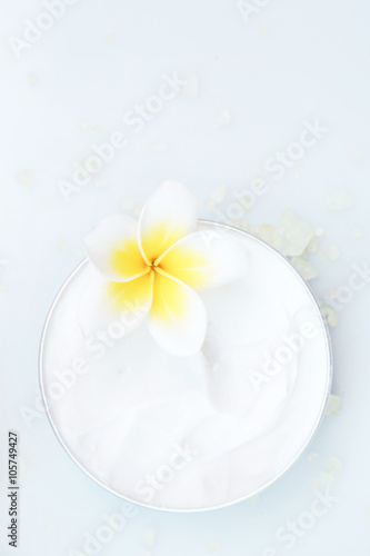 Top view of organic cream with frangipani flower