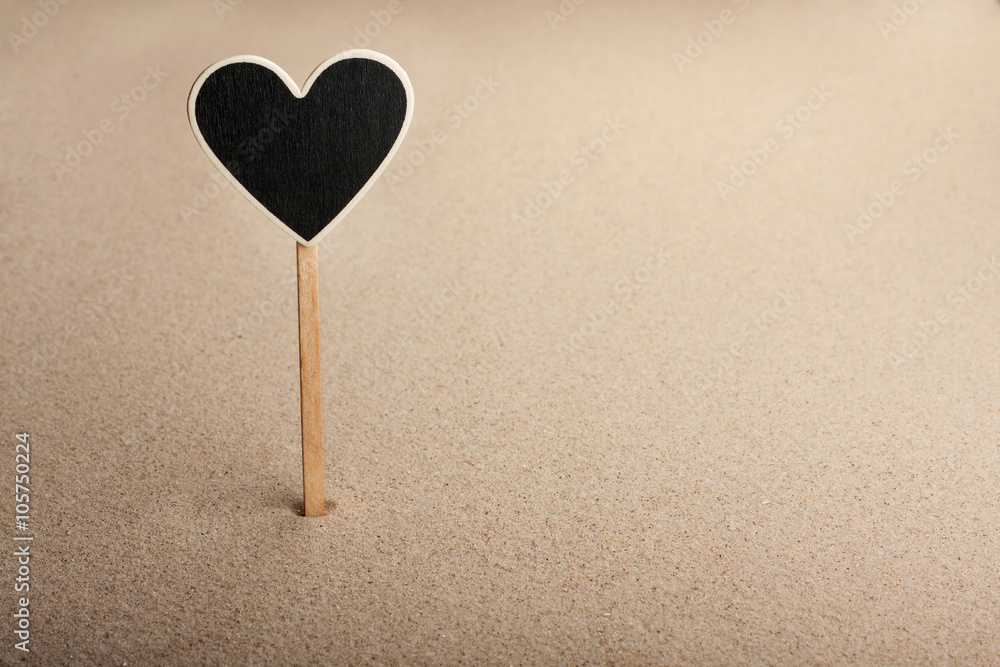 Fototapeta premium Pointer, ads board in the form heart in the sand