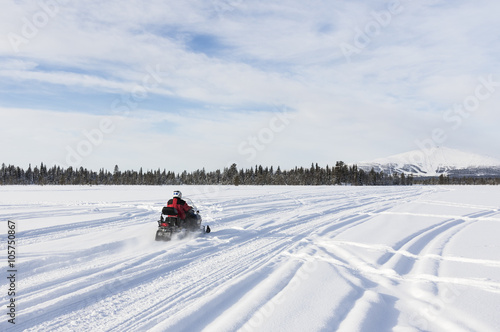 Going with snowmobile towards to mountain in Lapland