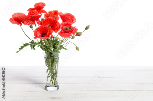 Fototapeta Naklejka Na Ścianę i Meble -  Bouquet of red poppies in glass vase on old white wooden table