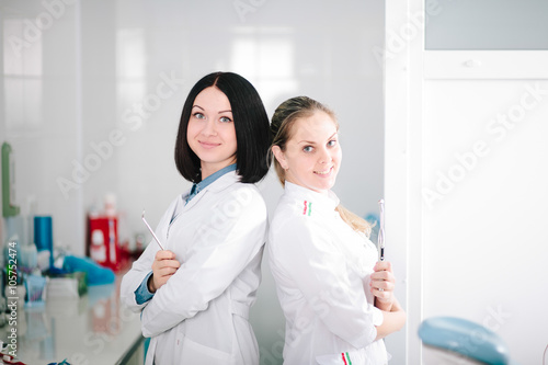 Young beautiful girls - dentist prepares the tooth to treat the patient.