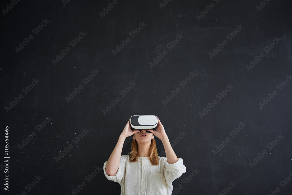 The girl in white stands on a black background in the virtual reality helmet - obrazy, fototapety, plakaty 