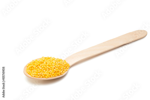 millet in a wooden spoon isolated