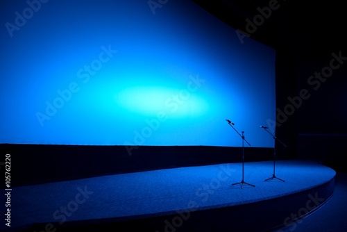 Empty stage in blue light with two microphones