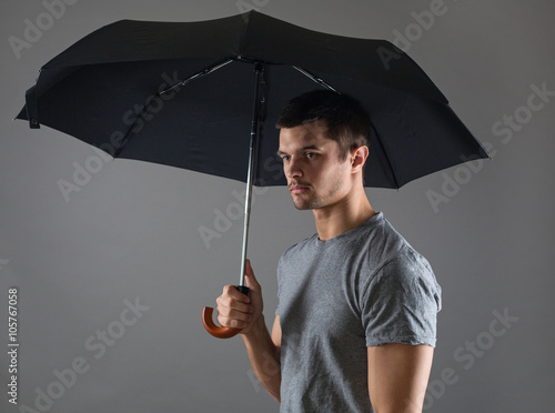 Portrait of a young man with a black umbrella © Okssi