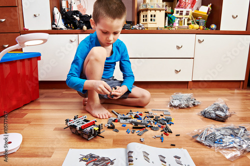 Foto Little boy collects plastic constructor