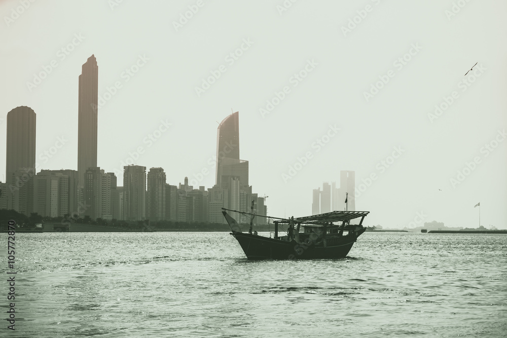 Fototapeta premium Abu Dhabi buildings skyline with old fishing boat