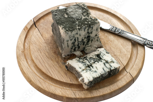 Sliced moldy lump of white cheese and knife on wooden tray isolated on white background