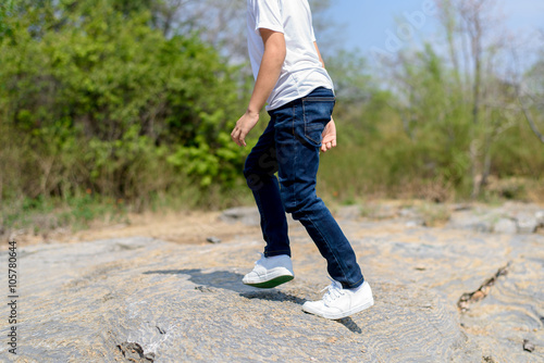Boy walking on the rocky land.